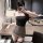 Woman wearing manny night leopard print lingerie set with matching bra and skirt, posing in a modern room.