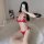Woman wearing red lace bra and panty set, posing on white rug with phone covering face.