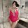 Woman wearing vibrant pink lace bodysuit with open-crotch design in modern bathroom setting.