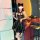 Woman in shiny black pvc catwoman costume with lace-up bodysuit, garter belt, cat ears, holding wine glass at bar.