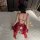 Woman in red bunny girl lingerie with open-crotch design, sheer lace, and tail—perfect for cosplay or sleepwear.