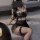 Woman wearing black lace lingerie set with fishnet stockings, featuring no-remove bra and matching outfit for small to plus s...