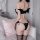 Woman wearing black pvc devil wings lingerie set with matching thong and stockings, anime-style cosplay outfit for women.
