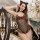Woman wearing hot cat-themed sexy lingerie bodysuit with leopard print, black fishnet mesh, and cat ears in elegant setting.