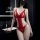 Woman wearing red lace bodysuit with cut-out details in modern bathroom setting.