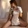 Woman modeling white vintage-style lace corset set with black trim and side buckles, inspired by retro qipao design, on a sof...