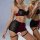 Woman modeling french-style lace lingerie set with sheer panels, burgundy accents, and garter straps.