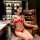A woman sits elegantly in a leather chair wearing a red lace lingerie set, featuring a 3-piece design with an open-crotch sty...