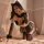 Woman modeling mannyan leopard print catwoman costume set with ears, gloves, and lingerie on bed.