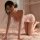Woman in pink sheer manyan floral butterfly lingerie set, kneeling on bed with floral hairpiece and butterfly details.