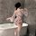 Woman wearing pink floral nightsiyese lingerie set with bow, standing by bathtub in japanese-inspired costume.