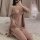 Woman wearing plus size deep v lace sleep set with transparent mesh babydoll, thong, and robe on bed.