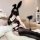 Woman in qingruohan black lace lingerie set with bunny ears, heart mask, and thigh-high stockings on bed.