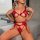 A woman poses wearing a red lace bodysuit set featuring cut-out details, perfect for festive occasions like christmas parties...