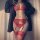 Woman wearing red lace lingerie set with garter belt, stockings, and open-crotch design under black blazer.