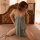Woman wearing suoqing sexy lace sleep dress with side slit and adjustable ties, posing on bed in soft lighting.