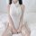 A woman sits on a bed wearing a white liquid-fitted dress with sheer mesh thigh-high stockings adorned with bows, perfect for...