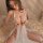 A woman models the pure & playful lingerie set, featuring a delicate white design with lace detailing and sheer fabric, perfe...