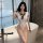 A woman poses elegantly in a white qingruohan japanese-style sexy lingerie bodysuit featuring a cute tie-up design, highlight...
