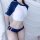A stylish swimsuit set featuring a white crop top with navy blue accents and matching bikini bottoms, perfect for adults seek...