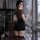 A woman stands by a window wearing a leopard print top with a black mini skirt, paired with lace stockings, showcasing a luxu...