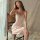 Elegant woman wearing a silky beige dress by mannyan, featuring delicate spaghetti straps and a v-neckline, perfect for luxur...