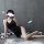 A woman poses in a black qingran sexy lace chemise set, featuring a backless design with a slit, perfect for sleepwear or lou...