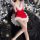 A woman poses in a festive christmas-themed outfit, featuring a red mini skirt with white fur trim and matching lace lingerie...