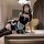 A woman poses in a luxurious room wearing a black and white maid costume sleepwear set from pure & playful. the outfit featur...