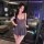 A woman poses elegantly in a stylish, form-fitting gray dress with a plunging neckline and flared skirt. the outfit features ...