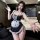 A woman poses in a black lace maid costume featuring a sexy sleep dress with a detachable apron and headband, perfect for rol...