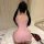 Woman wearing pink plus size sexy nurse costume, back view showing curvy fit and heart detail, with red heels nearby.