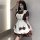 A woman poses wearing a maid-themed dress, featuring a cream and brown color scheme with ruffles and bows, perfect for anime ...