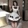 A woman poses in a maid lolita outfit, featuring a cream dress with brown accents, bows, and ruffles, perfect for anime-theme...