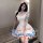 A woman wears a charming maid lolita dress with pastel pink and blue accents, featuring ruffles and bows, perfect for anime-t...