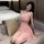 A woman lounges on a couch wearing a delicate pink juhuo sexy lingerie set, featuring a lace cami and flowing skirt, perfect ...