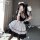 A woman poses in a japanese lolita maid costume set, featuring a black lace bodice and thigh-high stockings, holding a feathe...
