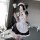A woman poses in a fantasy romance maid dress, featuring a cute pure-yuri lolita apron outfit inspired by anime. the black an...