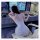 A woman wearing a floral lace contrast sexy low-cut slip dress sits on a gaming chair, facing a computer screen with headphon...