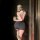 A woman poses in a mirror wearing a black bodycon dress paired with sheer stockings and ballet flats, holding a phone. the ou...