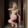 A woman poses in a bunny costume featuring a sheer open-crotch bodysuit with lace details and bunny ears, perfect for role pl...