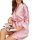 A woman wearing a pink striped satin robe, holding an open magazine, exuding comfort and style.