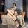 A stylish woman poses on a cozy chair wearing night sensual open-crotch pantyhose set, featuring nude stockings and garter ...