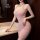 A woman poses elegantly in a luxurious pink bodycon mini dress featuring a deep v-neckline, perfect for evening events.