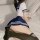 A person wearing a school uniform skirt and thigh-high stockings sits on a bed, showcasing an intimate setting. the scene hig...