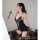 A woman poses elegantly holding white flowers, wearing a black lace lingerie set with sheer stockings and matching panties, d...