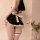 A woman models a maid costume lingerie set featuring a black dress with white ruffles and a bow, paired with thigh-high stock...