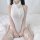 A woman sits on a bed wearing a white liquid-fitted dress with sheer mesh thigh-high stockings adorned with bows, perfect for...