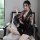 A woman sits on a chair wearing a japanese kimono-style lingerie set with floral patterns, featuring a deep v neckline and no...