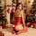 A woman poses in a festive setting, wearing a red luxury bodysuit with a deep v-neckline and playful white accents. the outfi...
